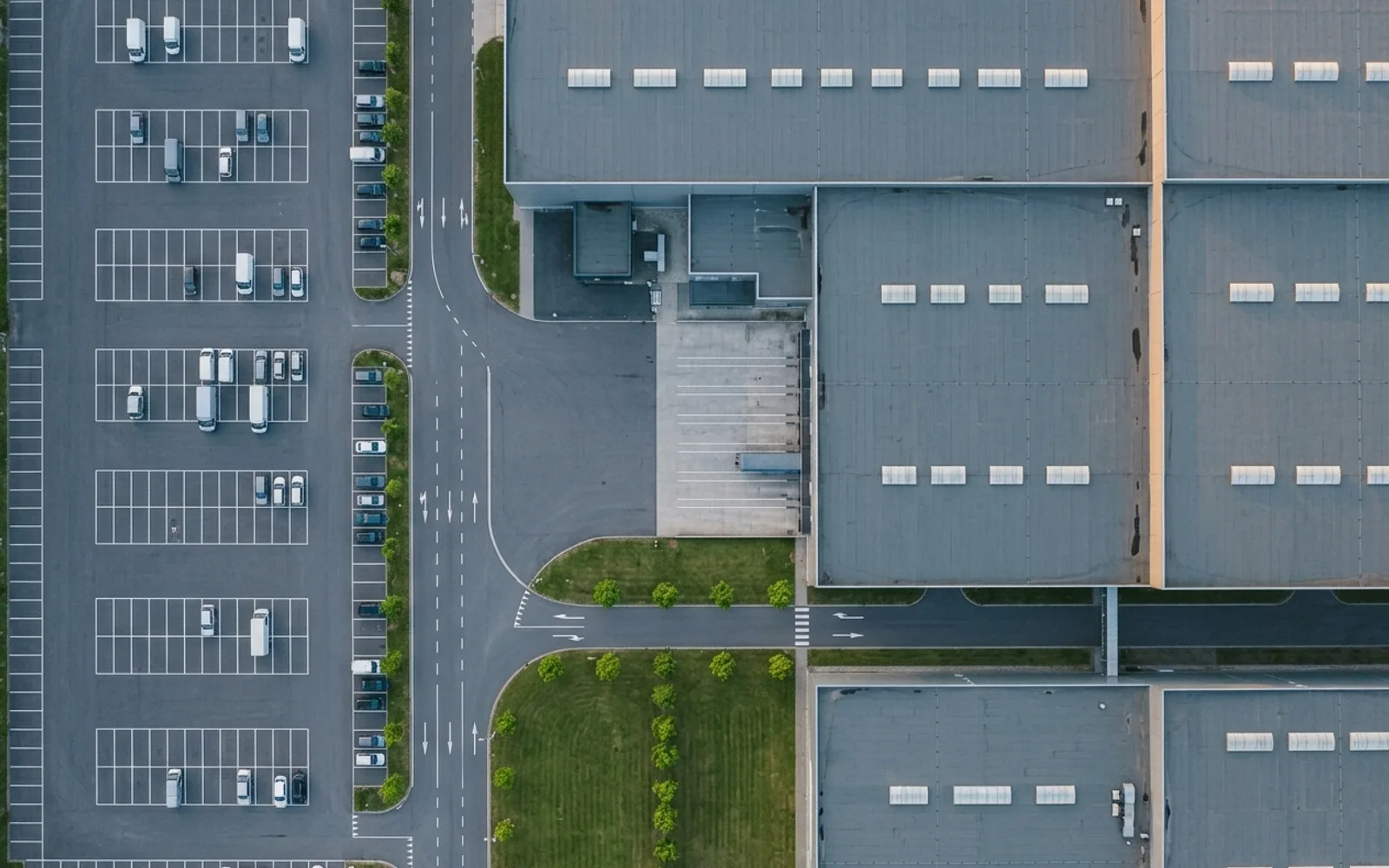 Gewerbegebiet mit Hallen und Parkplätzen exakt senkrecht von oben, Orthofoto-Ansicht